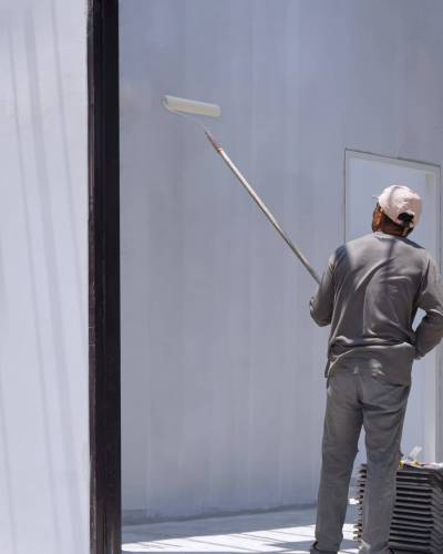 asian-builder-worker-painting-white-primer-concrete-wall-inside-house-construction-site